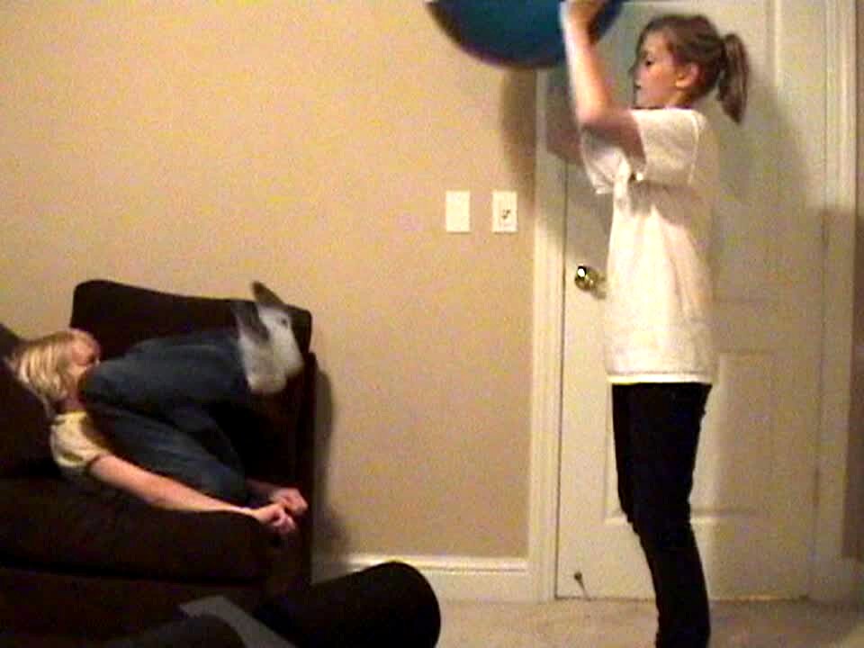 Video thumbnail showing: Girl & boy play with an exercise ball. Boy accidentally kicks the ball in girl's face.