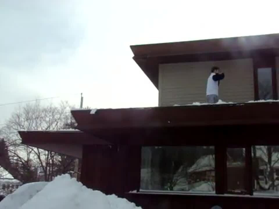 Video thumbnail showing: 2 shirtless teen boys jump off the roof and land on a large snow pile. Stunt. Winter.