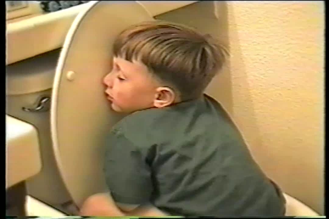 Video thumbnail showing: Boy falls asleep on toilet in strange position.