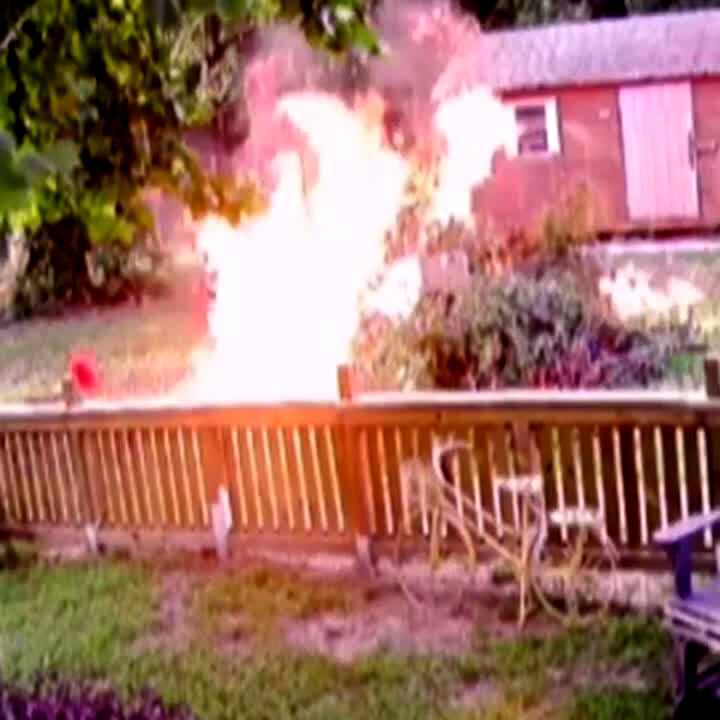 Video thumbnail showing: A man lights a pile of leaves drenched in gasoline on fire and it explodes, then he does a backflip in a yard. Security camera footage.